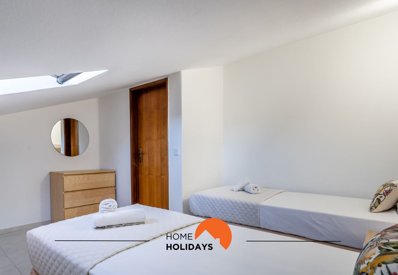 Quarto camas individuais com claraboia, decoração minimalista