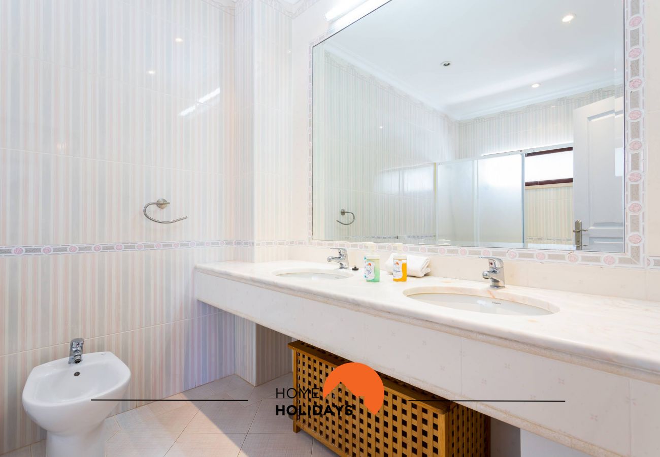 Casa de banho com bidé, lavatório e espelho
